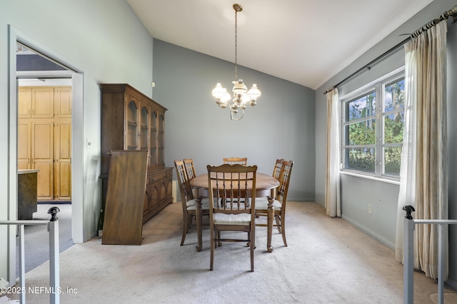 dining room featuring lofted ceiling, light colored carpet, and an inviting chandelier