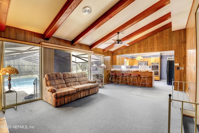 living room featuring light carpet, beam ceiling, and wood walls