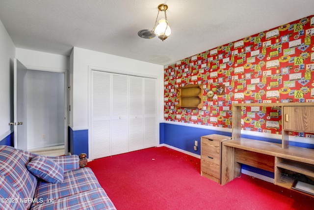 carpeted bedroom featuring a textured ceiling and a closet