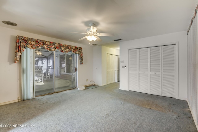 unfurnished bedroom with carpet, two closets, access to exterior, and ceiling fan