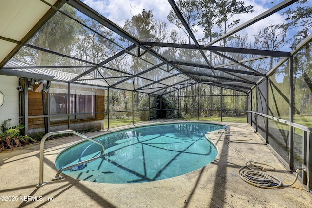 view of pool with a patio area and glass enclosure