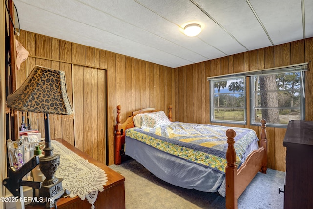 bedroom with light carpet and wood walls