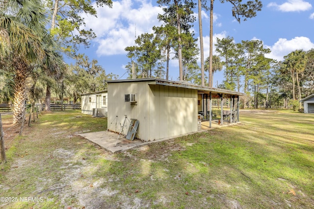 view of side of property featuring a yard and a wall mounted AC