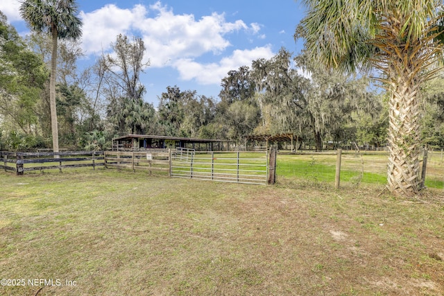 view of yard with a rural view and an outdoor structure