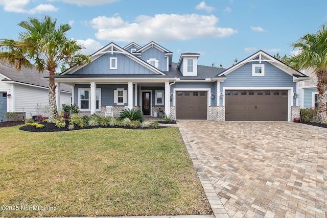 craftsman house featuring a garage, a porch, and a front yard