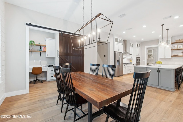 dining room with built in desk and light hardwood / wood-style floors