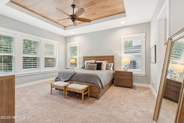 bedroom with a raised ceiling, ceiling fan, light colored carpet, and wood ceiling