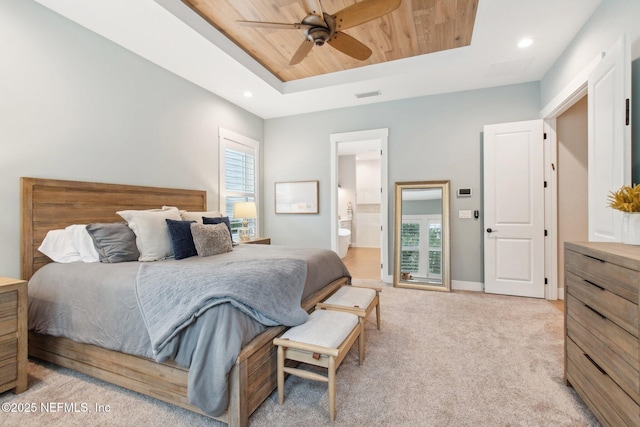 carpeted bedroom with ceiling fan, ensuite bathroom, a tray ceiling, and wooden ceiling