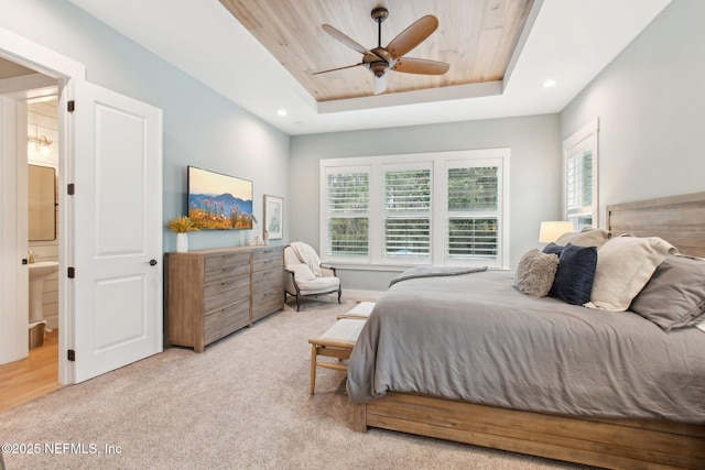 carpeted bedroom featuring ceiling fan, a raised ceiling, ensuite bath, and wooden ceiling