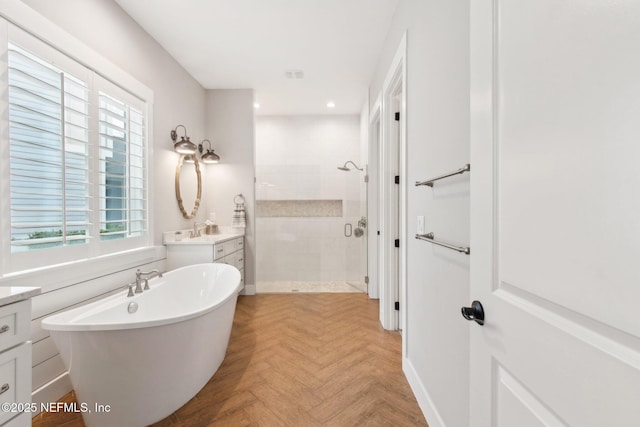 bathroom featuring parquet flooring, vanity, and shower with separate bathtub