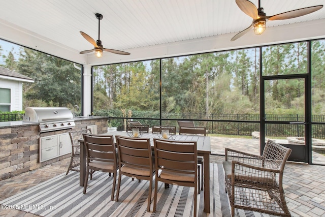 sunroom / solarium featuring ceiling fan and a wealth of natural light