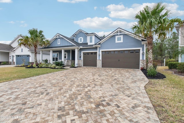 craftsman inspired home featuring a porch, a garage, and a front yard