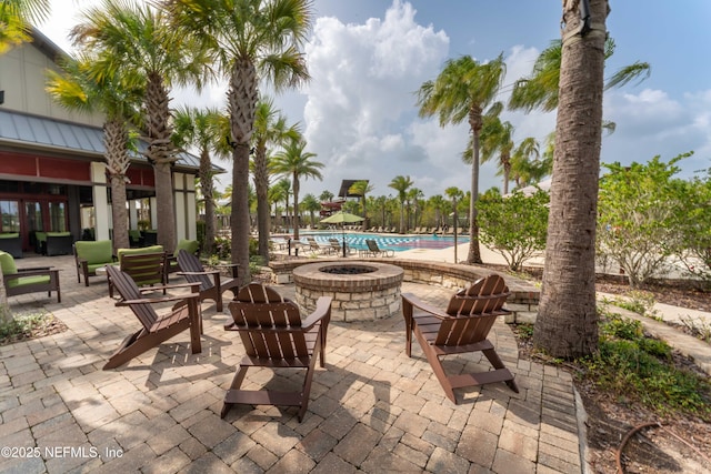 view of patio featuring a community pool and an outdoor fire pit