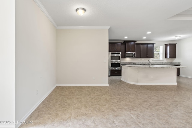 kitchen with sink, a kitchen island with sink, stainless steel appliances, dark brown cabinetry, and ornamental molding