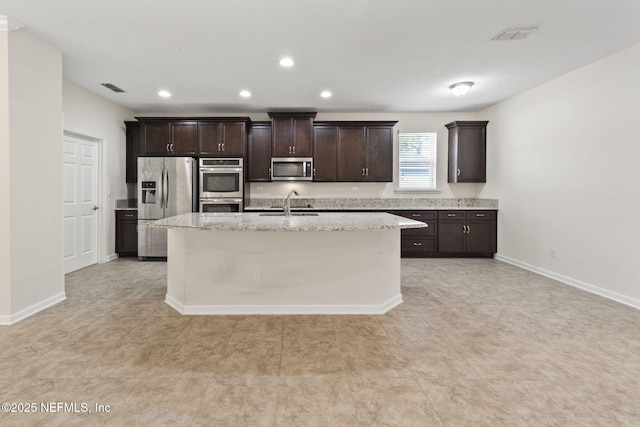 kitchen featuring stainless steel appliances, dark brown cabinets, sink, and a center island with sink