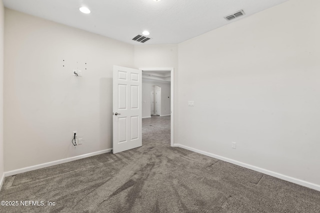 spare room with dark carpet