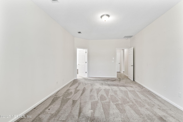 carpeted empty room featuring a textured ceiling