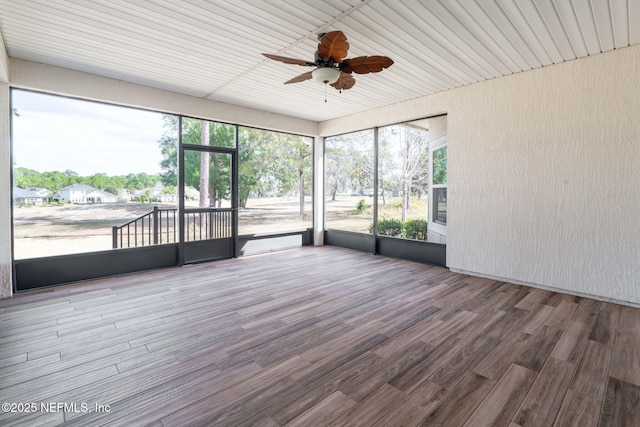 unfurnished sunroom with ceiling fan