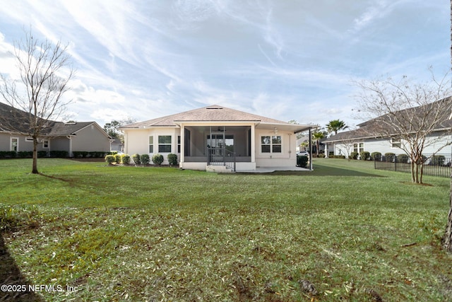 back of house with a sunroom and a lawn