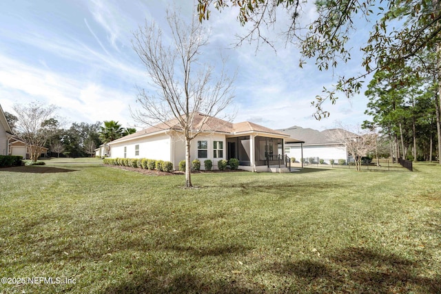 back of house with a sunroom and a lawn