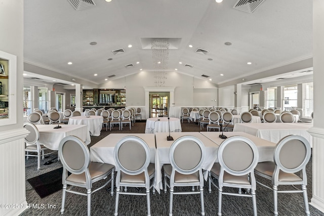 dining space with crown molding, lofted ceiling, and plenty of natural light