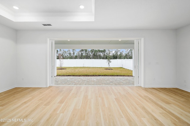 unfurnished room with a healthy amount of sunlight, a raised ceiling, and hardwood / wood-style floors