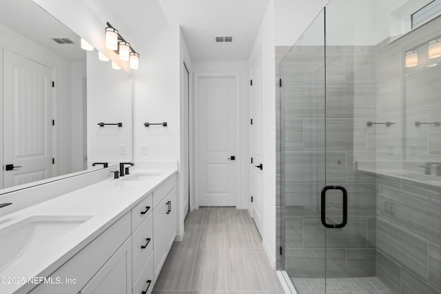 bathroom featuring vanity, an enclosed shower, and tile patterned floors