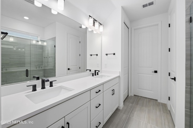 bathroom with vanity, an enclosed shower, and tile patterned flooring