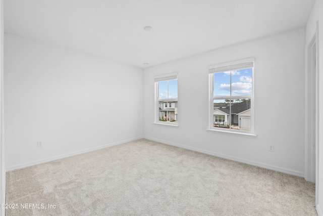 spare room featuring light colored carpet