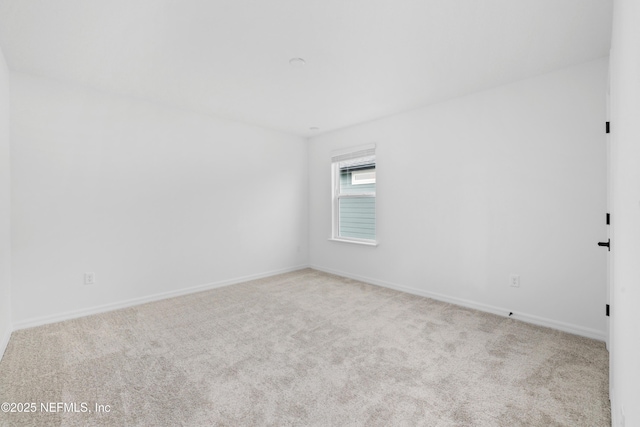 spare room featuring light colored carpet