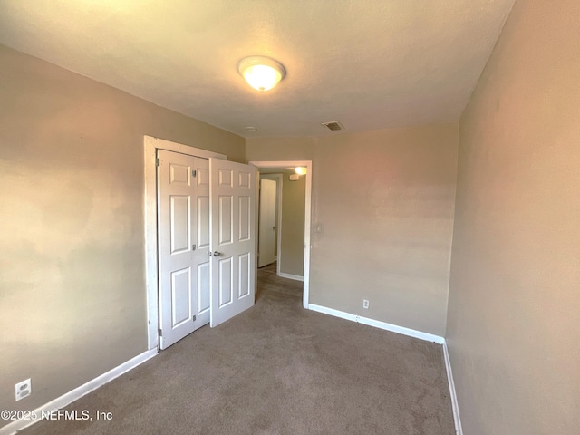 unfurnished bedroom featuring light carpet and a closet