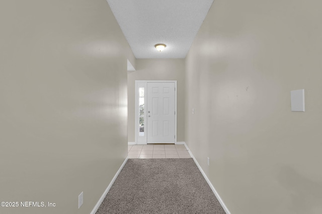 doorway featuring light carpet and a textured ceiling