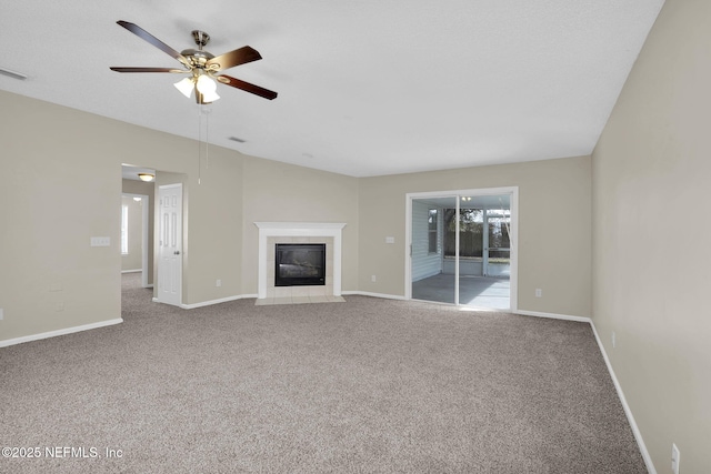 unfurnished living room with a tile fireplace, carpet flooring, and ceiling fan