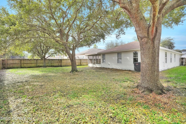 view of yard featuring central AC unit and a sunroom