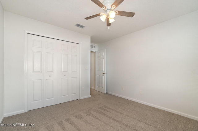 unfurnished bedroom with carpet floors, ceiling fan, and a closet