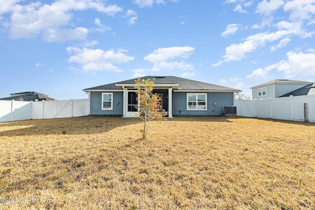 back of house featuring a yard and central AC unit