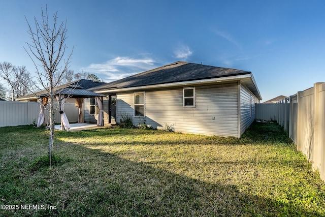 rear view of property with a gazebo, a yard, and a patio