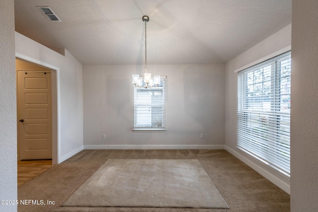 unfurnished room with light colored carpet and a chandelier