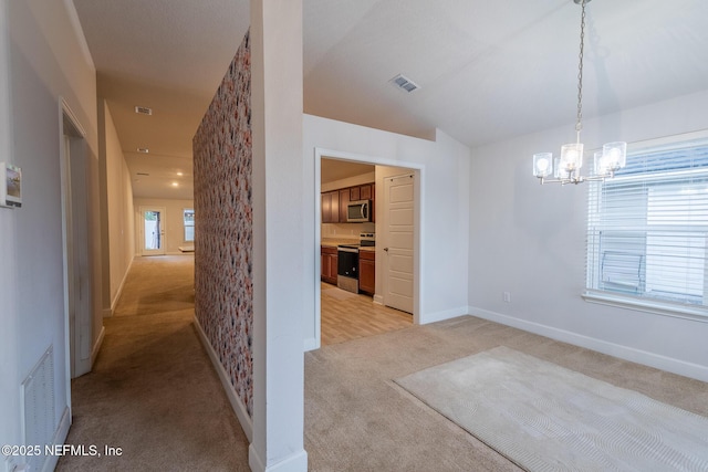 unfurnished dining area featuring light carpet and an inviting chandelier