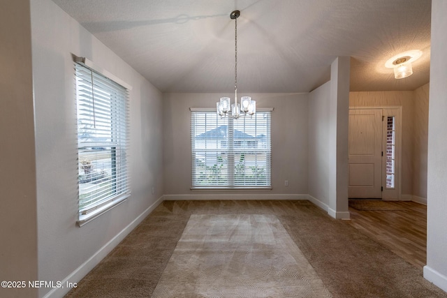 unfurnished dining area featuring a notable chandelier, carpet, and a healthy amount of sunlight