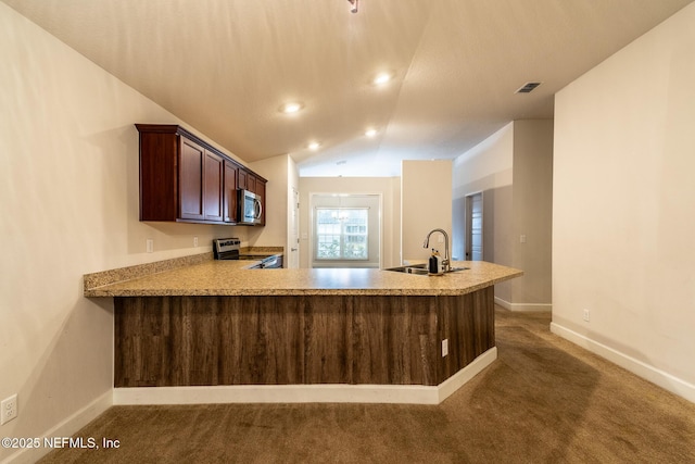 kitchen featuring kitchen peninsula, dark carpet, appliances with stainless steel finishes, sink, and lofted ceiling