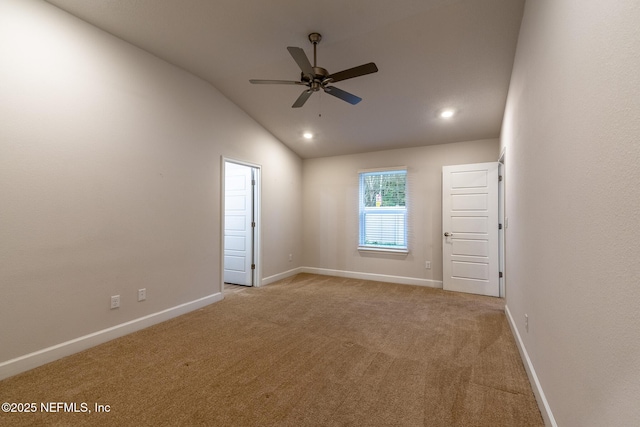 carpeted empty room with vaulted ceiling and ceiling fan