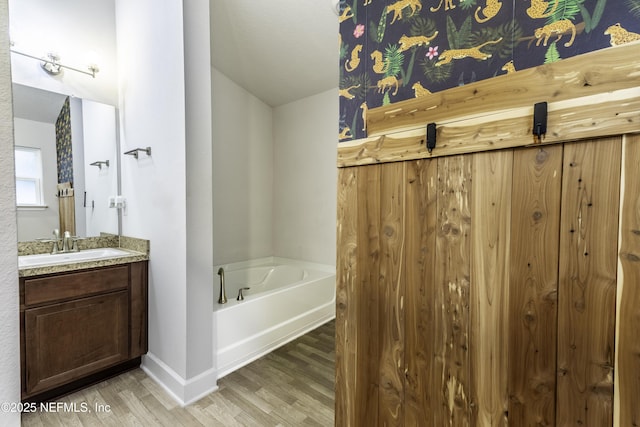 bathroom featuring vanity, a tub, and hardwood / wood-style floors