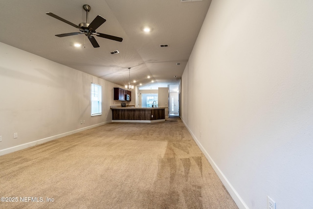 unfurnished living room with vaulted ceiling, ceiling fan, and light colored carpet