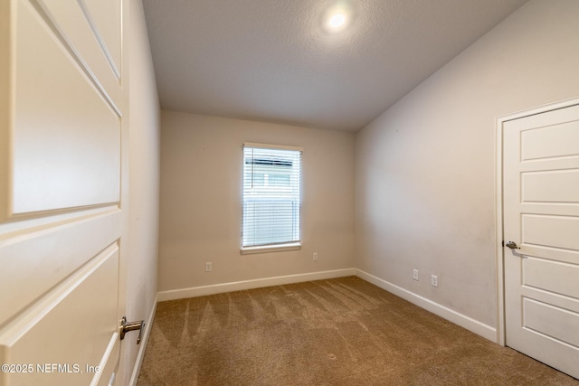 empty room with a textured ceiling and carpet floors