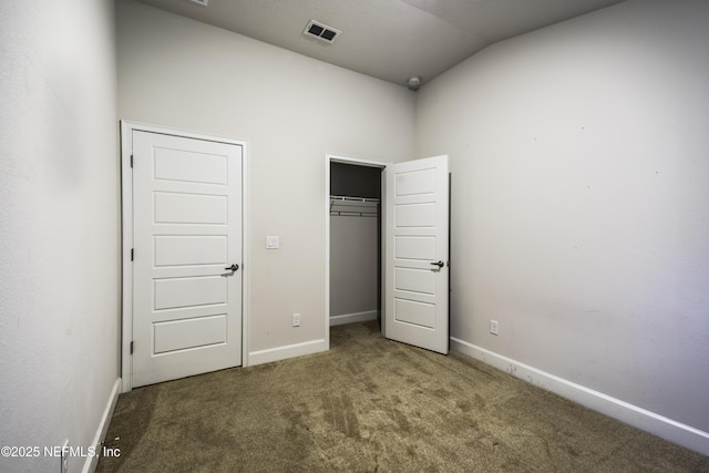 unfurnished bedroom featuring dark colored carpet and vaulted ceiling