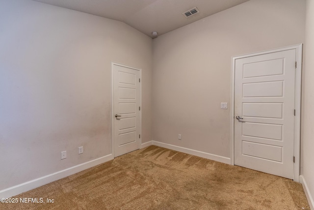 empty room featuring carpet flooring and lofted ceiling