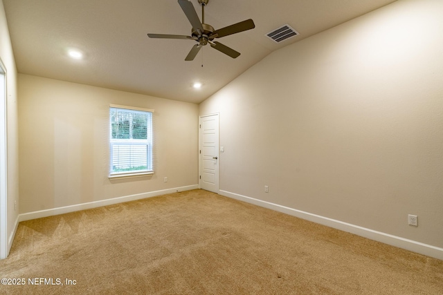 spare room featuring vaulted ceiling, ceiling fan, and light colored carpet