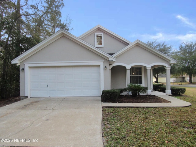 view of front of house featuring concrete driveway, an attached garage, and stucco siding