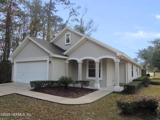 view of front of home featuring a garage, covered porch, driveway, and stucco siding